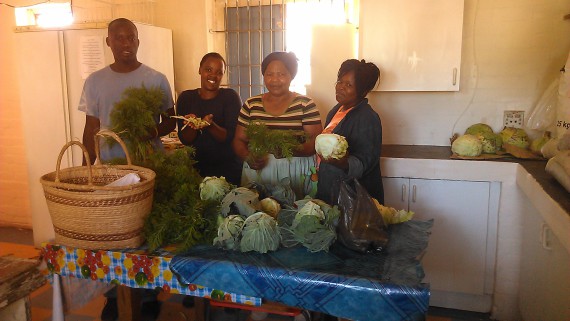 In holiday spirit, Umpheki Noks celebrates with the SA SDI Alliance and Masi Pink House staff at the Masi Soup Kitchen after the harvest of vegetables for christmas dishes of imifino (greens), seshebo (stew) and umngqusho (mash)