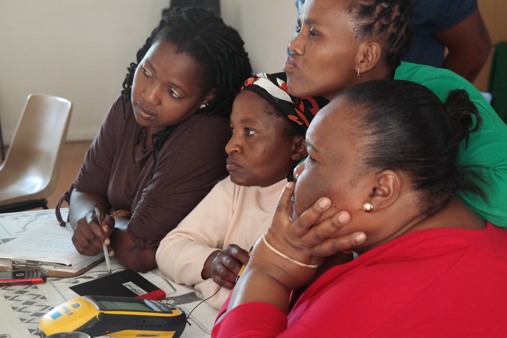 Community enumerators learn the basics of conducting a household-level survey using a data collection device called the Trimble during an enumerations training workshop.